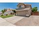 Lovely home with a well-manicured lawn, neutral exterior, and spacious driveway with brick accents at 1705 W Lark Dr, Chandler, AZ 85286
