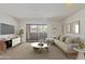 Bright living room featuring a stylish couch, modern decor, and sliding glass doors to outdoor balcony at 1730 W Emelita Ave # 2033, Mesa, AZ 85202