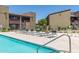 Community pool area with lounge chairs surrounded by landscaped grounds and multiple building access stairs at 1730 W Emelita Ave # 2033, Mesa, AZ 85202