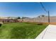 Backyard featuring artificial grass, a hammock, cornhole and other yard games for outdoor relaxation at 17980 W Meadowbrook Ave, Goodyear, AZ 85395
