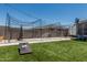 Spacious backyard featuring a batting cage, artificial grass and other yard games for outdoor activities at 17980 W Meadowbrook Ave, Goodyear, AZ 85395