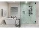 Modern bathroom showcasing soaking tub and glass-enclosed shower with marble-style tile at 17980 W Meadowbrook Ave, Goodyear, AZ 85395
