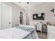 Bedroom featuring a desk, wall-mounted television, and light-colored walls and flooring at 17980 W Meadowbrook Ave, Goodyear, AZ 85395