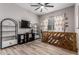 This bedroom features stylish wood-look flooring, tv, and large window at 17980 W Meadowbrook Ave, Goodyear, AZ 85395