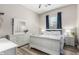 Bright bedroom featuring a white bed frame, dresser with mirror, and wood-look flooring at 17980 W Meadowbrook Ave, Goodyear, AZ 85395