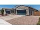 Stucco home featuring a large garage, desert landscaping, and a paved driveway at 17980 W Meadowbrook Ave, Goodyear, AZ 85395