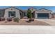 Charming single-story home featuring a stucco exterior, blue shutters, and desert landscaping at 17980 W Meadowbrook Ave, Goodyear, AZ 85395