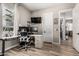 Well-lit home office features wood-look floors, black office chair and dual monitors at 17980 W Meadowbrook Ave, Goodyear, AZ 85395