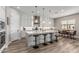 Bright eat-in kitchen with white cabinetry, stainless appliances, and pendant lighting above a large island at 17980 W Meadowbrook Ave, Goodyear, AZ 85395