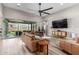 Open-concept living room with wood floors, modern furnishings, and a sliding glass door to the backyard at 17980 W Meadowbrook Ave, Goodyear, AZ 85395