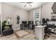 Home office with a large desk, comfortable seating area, and natural light from the window at 17980 W Meadowbrook Ave, Goodyear, AZ 85395