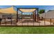 Backyard playground featuring a climbing wall, swings, a playhouse and artificial grass at 17980 W Meadowbrook Ave, Goodyear, AZ 85395