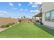 Backyard featuring lush artificial grass, an outdoor patio set, a playset, and a block wall for privacy at 1800 S Jesse Pl, Chandler, AZ 85286