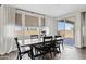 Dining area featuring a wood table with black chairs, a patio slider, and bright windows with privacy shades at 1800 S Jesse Pl, Chandler, AZ 85286