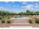 Community pool and spa with beautiful landscaping and blue skies in a park-like setting at 1800 S Jesse Pl, Chandler, AZ 85286