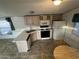Functional kitchen featuring light wood cabinetry, modern appliances, and a cozy dining area at 201 S Greenfield Rd # 118, Mesa, AZ 85206