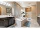 Bright bathroom with a soaking tub and separate vanities with dark cabinetry at 22851 S 229Th Pl, Queen Creek, AZ 85142