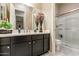Bathroom featuring dark cabinetry, a glass-enclosed shower, and neutral tile floors at 22851 S 229Th Pl, Queen Creek, AZ 85142