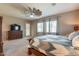This bedroom features a windmill ceiling fan, large windows, and a dresser at 22851 S 229Th Pl, Queen Creek, AZ 85142