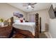 Bedroom boasts a wooden four-poster bed, ceiling fan, and mounted TV at 22851 S 229Th Pl, Queen Creek, AZ 85142