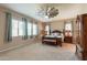 Spacious bedroom featuring a unique ceiling fan, large windows, and a beautifully appointed bed at 22851 S 229Th Pl, Queen Creek, AZ 85142