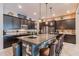 This expansive kitchen features dark cabinets, granite countertops, pendant lighting, and seating around the island at 22851 S 229Th Pl, Queen Creek, AZ 85142