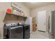 Bright laundry room featuring a modern washer and dryer set, and ample shelving space for storage at 22851 S 229Th Pl, Queen Creek, AZ 85142