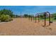 Community playground featuring swings, play structures, and wood chip ground cover at 22851 S 229Th Pl, Queen Creek, AZ 85142