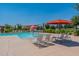 Community swimming pool featuring lounge chairs, umbrellas, and a splash pad at 22851 S 229Th Pl, Queen Creek, AZ 85142