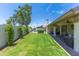 Lush green backyard featuring a well-manicured lawn, privacy fence, and cozy patio seating at 3611 E Dartmouth Cir, Mesa, AZ 85205