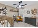 A cozy Bedroom features a wooden crib, rocking chair, and a modern ceiling fan at 3611 E Dartmouth Cir, Mesa, AZ 85205