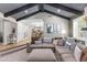 Open concept living room with kitchen access features wood beamed ceiling and comfortable seating, perfect for modern living at 3611 E Dartmouth Cir, Mesa, AZ 85205
