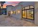 A warm home exterior with a large stone patio and sliding glass doors to dining area, perfect for outdoor entertaining at 3800 E Lincoln Dr # 54, Phoenix, AZ 85018