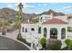 Mediterranean-style home with red tile roof, white stucco, and lush landscaping set against a mountain backdrop at 3800 E Lincoln Dr # 54, Phoenix, AZ 85018