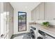 Well-organized laundry room featuring modern washer/dryer and abundant cabinet space with beautiful outside view at 3800 E Lincoln Dr # 54, Phoenix, AZ 85018