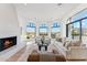Bright living room featuring a fireplace, floor-to-ceiling windows, a pitched ceiling, and hardwood floors with a warm, inviting feel at 3800 E Lincoln Dr # 54, Phoenix, AZ 85018