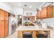Kitchen island with seating, leading to stainless steel refrigerator at 3828 N Rosewood Ave, Avondale, AZ 85392