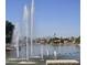 Scenic lake view showcases water fountains, waterfront homes, lush greenery, and distant mountains on a sunny day at 3828 N Rosewood Ave, Avondale, AZ 85392
