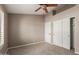 Bedroom with neutral carpet and walls featuring closet and a ceiling fan at 408 W Stacey Ln, Tempe, AZ 85284