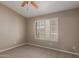 This neutral bedroom features a ceiling fan, neutral carpet, and adjustable shuttered window at 408 W Stacey Ln, Tempe, AZ 85284