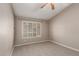 Neutral carpeted bedroom features adjustable shuttered window and ceiling fan at 408 W Stacey Ln, Tempe, AZ 85284