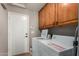 Laundry room boasts wood cabinets and white washer and dryer at 408 W Stacey Ln, Tempe, AZ 85284