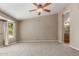 Spacious main bedroom with carpet flooring, a ceiling fan, and ensuite bathroom at 408 W Stacey Ln, Tempe, AZ 85284