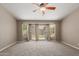 The main bedroom features carpet flooring, a ceiling fan, and sliding glass doors to the yard at 408 W Stacey Ln, Tempe, AZ 85284