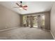 The main bedroom has carpet flooring, a ceiling fan, and sliding glass doors to the yard at 408 W Stacey Ln, Tempe, AZ 85284