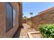 Side yard with rock ground cover, a low brick planter, and block fence at 408 W Stacey Ln, Tempe, AZ 85284