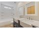 Bright bathroom featuring double farmhouse sinks, modern fixtures, and a tub and shower at 4212 W Tierra Buena Ln, Phoenix, AZ 85053