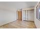Bright bedroom with wood-look tile flooring, closet with built-in storage, and door to adjacent room at 4212 W Tierra Buena Ln, Phoenix, AZ 85053