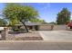 Charming single-story home with a lush green tree, desert landscaping and a spacious three-car garage at 4212 W Tierra Buena Ln, Phoenix, AZ 85053