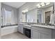 Elegant bathroom with double vanities, granite countertops, and a separate soaking tub under a window at 4302 E Cynthia St, Gilbert, AZ 85295